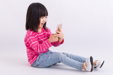 小女孩开心的看着手机