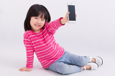 小女孩拿着手机坐在地上