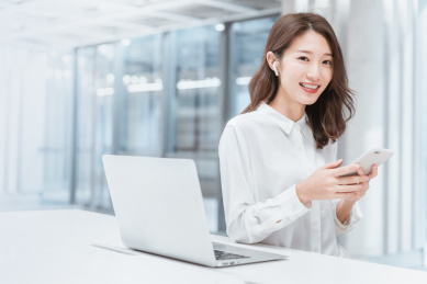 亚洲商务人士在室内办公区看手机