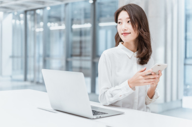 亚洲商务人士在室内办公区看手机