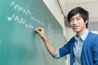 男大学生在黑板上写字