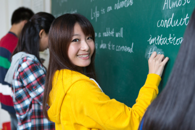 女大学生在黑板上写字