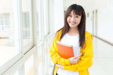 女大学生在教学楼里手持书本