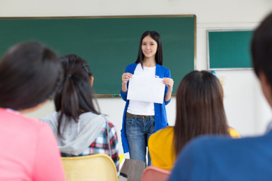 女大学生在教室里手持白板