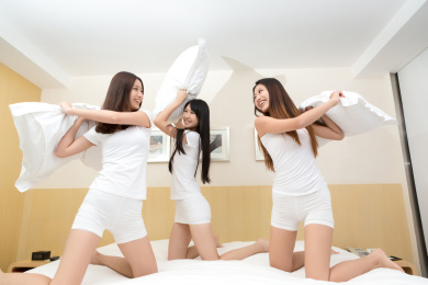 年轻女孩在卧室枕头大战