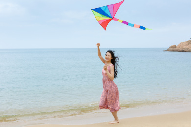 年轻女孩在海边放风筝