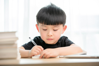  正在上网课的亚洲小男孩