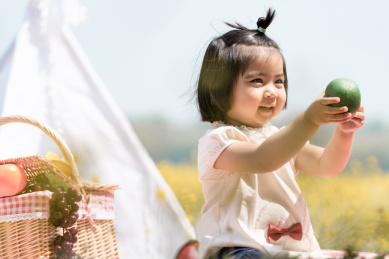 夏天坐在油菜花田边玩耍的女童