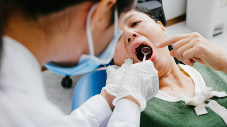 青年医生在给病人检查口腔