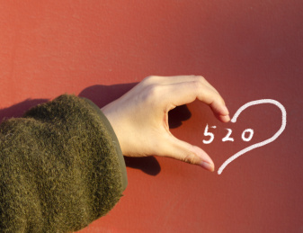 手与墙上的粉笔拼出一个完整的心形，围着数