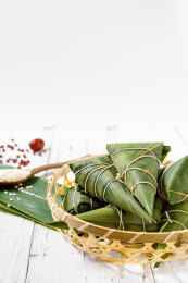 放在白木桌上的一筐新鲜手工粽子