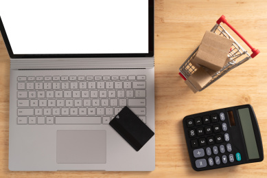 办公桌面上的笔记本电脑与购物车，网购概念