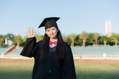 毕业生穿学士服挥手告别