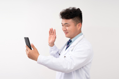 正在使用手机视频通话的亚洲男士医生
