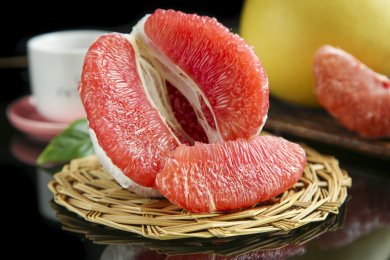 竹垫子上放着剥开的三红蜜柚和柚子果肉