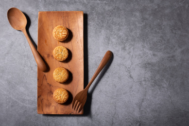 灰色背景上摆在木质托盘上的月饼