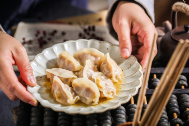 双手端着一盘饺子