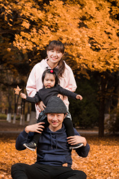 深秋在公园草地上的年轻父母和孩子