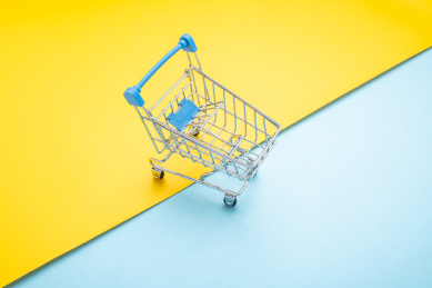 时尚撞色背景上一个购物车消费购物概念图 