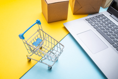 笔记本电脑和购物车网购消费概念图 