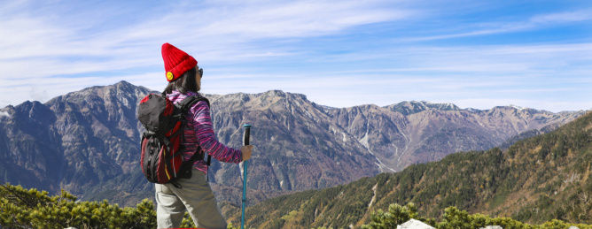站在山顶的女性徒步旅行者眺望群山风光