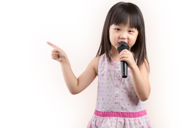 亚洲小女孩一手拿话筒一手指向一边