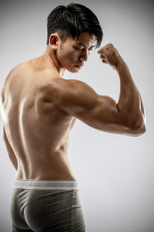 纯色背景里的健身肌肉男孩