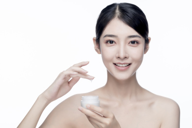 漂亮的亚洲美女抹面霜白色背景半身肖像