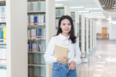 图书馆书架前的一个漂亮的女大学生
