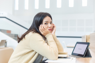 一名女大学生在图书馆看书看得很疲惫