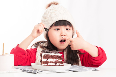 开心的吃夹心蛋糕的亚洲小女孩