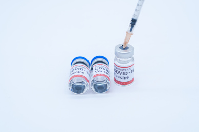 一支医疗注射器和三瓶疫苗