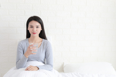 卧室里一名年轻女性在喝水