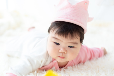 胖嘟嘟的婴儿趴在床上玩耍