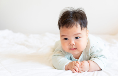 胖嘟嘟的婴儿趴在床上玩耍