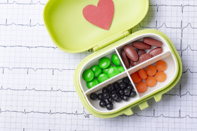 心心电图图纸上装有药丸的药盒和一颗红心