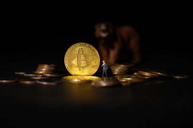 黑色背景上的商务人偶和金色比特币