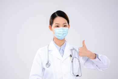 一位戴口罩的女医生伸出大拇指