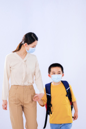 妈妈送戴着口罩的小男孩上学