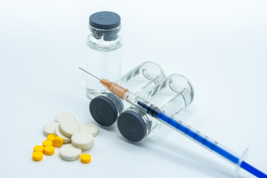 白色背景下的药片、疫苗和注射器针管