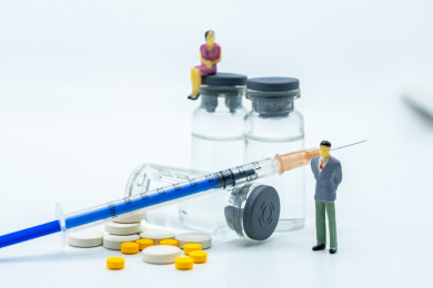 白色背景下的人物、疫苗和注射器针管