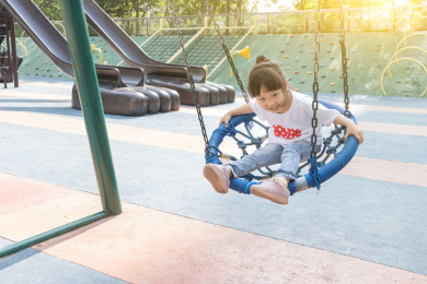 游乐场里坐秋千的小女孩