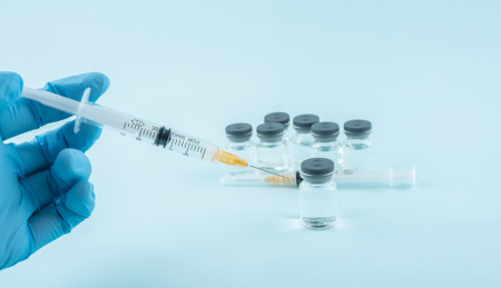 戴手套的医生手拿注射器打针   