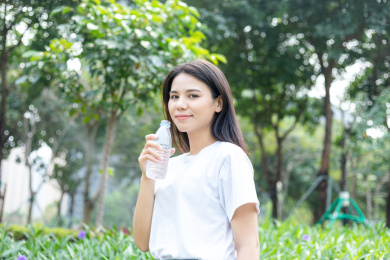一名年轻女性在户外喝矿泉水