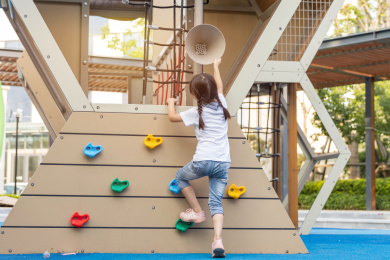 亚洲小女孩在游乐场里攀爬的背影