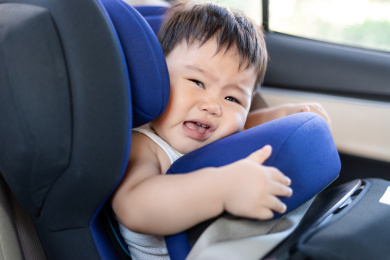 汽车里婴儿坐在安全座椅上哭闹