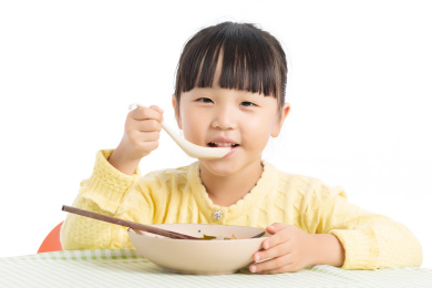 拿勺子喝粥的小孩子