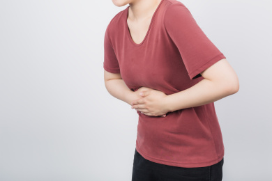 双手捂着腹部的亚洲女性