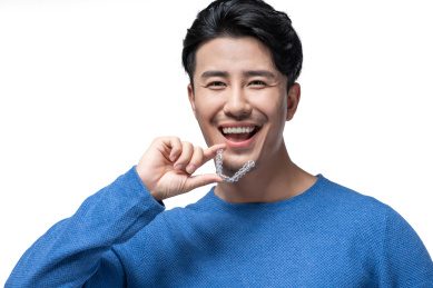 年轻男子拿着透明牙套