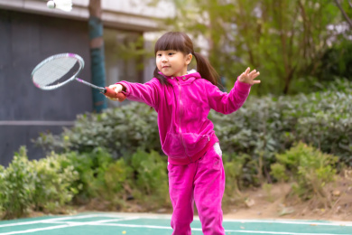 穿运动服打羽毛球的亚洲小女孩